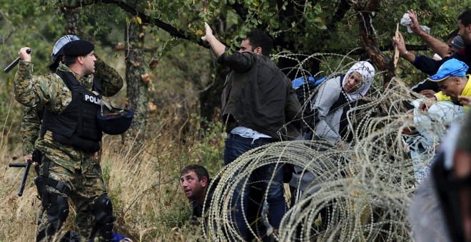 La Policía macedonia trata de detener a los refugiados que cruzan la frontera con Grecia, rumbo a Serbia, cerca de Gevgelija, Macedonia.- REUTERS / Ognen Teofilovski