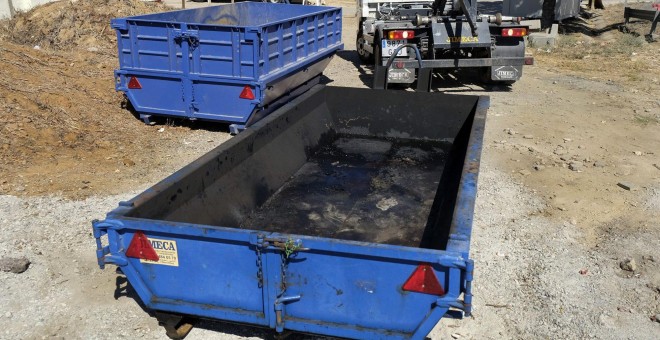 Una grúa se dispone a retirar el contenedor de residuos, donde fue encontrado el cadáver calcinado de una mujer de raza negra.- EFE
