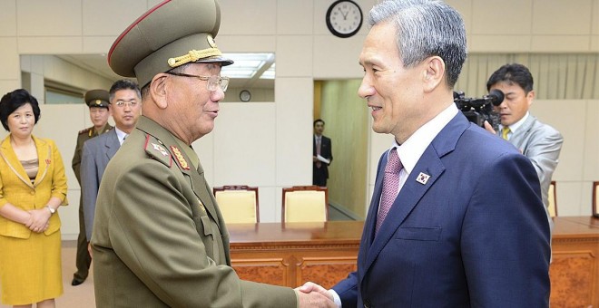 Los dos altos representantes de las dos Coreas se saludan tras llegar a un acuerdo para rebajar la tensión de los últimos días. /REUTERS