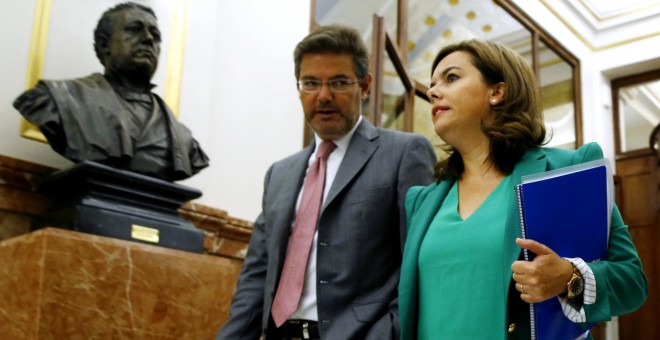 La vicepresidenta del Gobierno, Soraya Sáenz de Santamaría, con el ministro de Justicia, Rafael Catalá, a su llegada al pleno del Congreso que debate sobre el proyecto de Ley de Presupuestos para 2016. EFE/Sergio Barrenechea