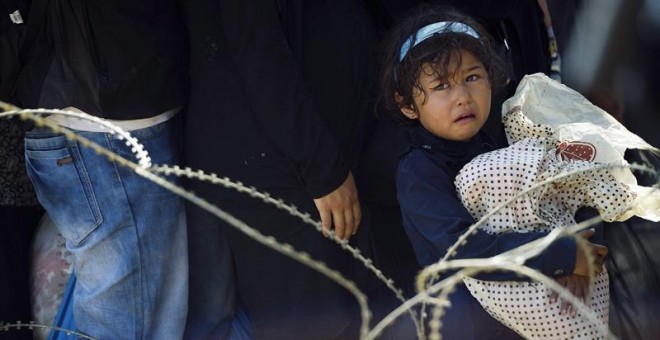 Una niña llora mientras miles esperan en el paso fronterizo de Macedonia y Grecia cerca de Gevgelija. Europa está a un paso de contabilizar las 300.000 llegadas de inmigrantes y refugiados desde que empezó este año, según la Agencia de las Naciones Unidas