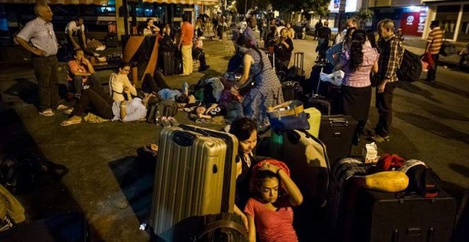 Un grupo de personas que solicita la salida de Venezuela hacia Colombia pasa la noche junto a algunas de sus pertenencias. / MIGUEL GUTIÉRREZ (EFE)