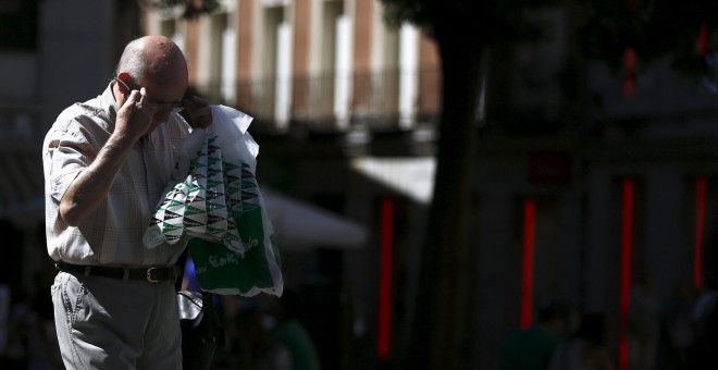 Un hombre con varias bolsas de El Corte Ingles. REUTERS/Sergio Perez