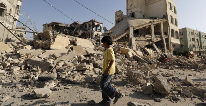 Un niño pasa junto a la casa del Brigadier Khaled al-Anduli, un comandante del ejército leal al movimiento Houthi, después de que fue golpeado por los ataques aéreos liderados por Arabia en la capital de Yemen, Saná. REUTERS