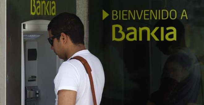 Un hombre retira dinero en un cajero de Bankia. EFE