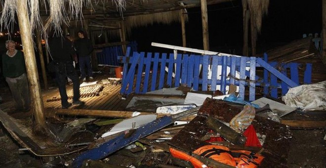 Un bombero pasa al lado de varios destrozos causados por una ola después del terremoto. - EFE