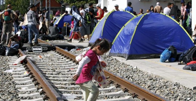 Refugiados descansan en tiendas de campaña instaladas en la estación de Tovarnik, Croacia. EFE/Antonio Bat