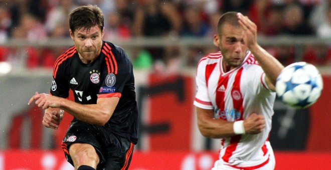 Xabi Alonso lanza un balón junto al el jugador Pajtim Kasami, durante partido entre Olympiacos y el Bayern Múnich de la Liga de Campeones. EFE/ALEXANDROS VLACHOS