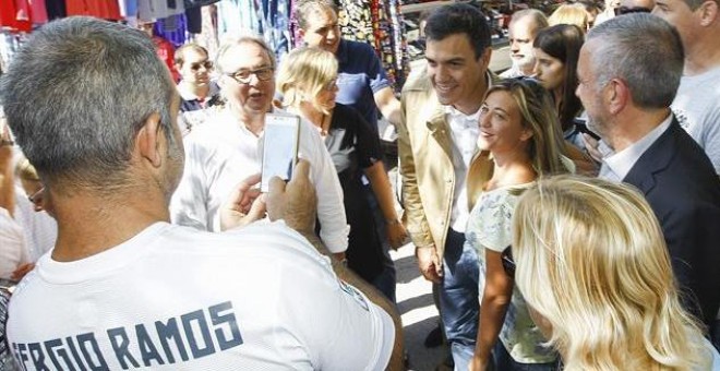 El secretario general del PSOE, Pedro Sánchez (c), se fotografía con una vecina en compañía del candidato del PSC a la presidencia de la Generalitat, Miquel Iceta, en el mercado semanal de Santa Perpètua de Mogoda.-EFE