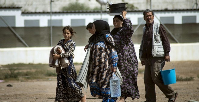 Una familia de refugiados sirios, a las puertas del CIE de Mellilla. REUTERS/ Jesus Blasco de Avellaneda