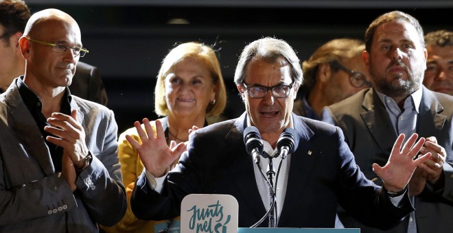 Artur Mas, entre Raul Romeva y Oruiol Junqueras, se dirige a los seguidores de Junts Pel Si, en la noche electoral del 27-S. REUTERS/Sergio Perez