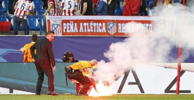 Un operario retira una de las bengalas lanzadas por hinchas del Benfica en el partido de anoche. /EFE