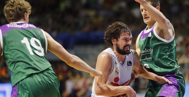 El escolta del Real Madrid Sergio Llull (c) entra a canasta ante el base serbio del Unicaja Nemanja Nedovic. /EFE