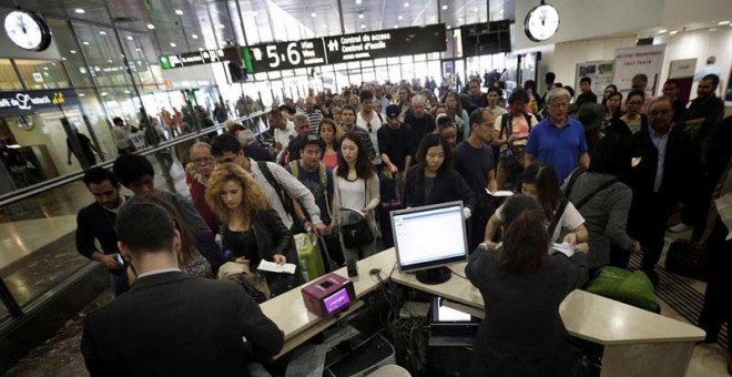 Cientos de pasajeros se agolpaban esta mañana en la estación de Sants de Barcelona a la espera de información. / ALBERTO ESTÉVERZ (EFE)