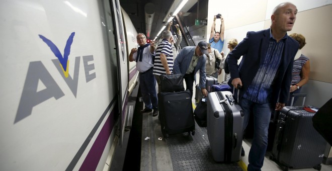 Pasajeros con sus maletas andando por un andén de la estación de Sans de Barcelona tras tener que bajarse de un tren AVE. /REUTERS