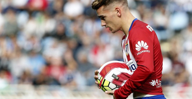 El delantero francés del Atlético de Madrid Antoine Griezmann, con el balón tras marcar el primer gol de su equipo ante la Real Sociedad, durante el partido de la octava jornada de Liga de Primera División que se juega hoy en el estadio de Anoeta de San