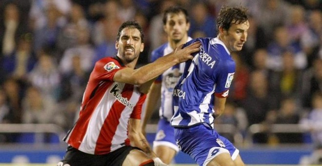 El centrocampista del Deportivo Pedro Mosquera (d) disputa un balón con Raúl García, del Athletic de Bilbao. /EFE