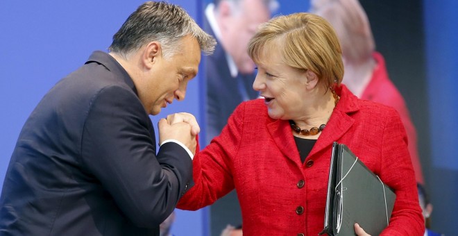 Viktor Orban besa la mano de la canciller Angela Merkel antes de su intervención en el Congreso del Partido Popular Europeo. - REUTERS