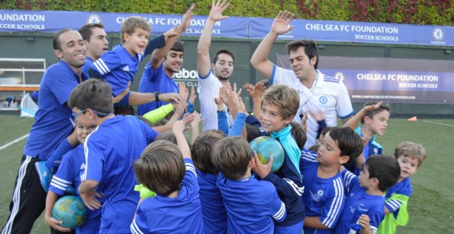 Los técnicos y los niños de la Fundación del Chelsea hacen piña tras un entrenamiento.