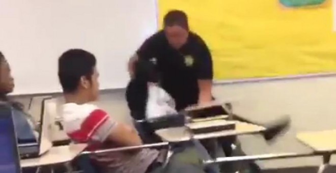 Captura del vídeo que muestra al policía reduciendo con violencia a una estudiante en actitud pacífica.