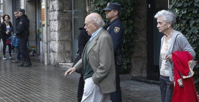 Jordi Pujol y su esposa, Marta Ferrusola, salen de su domicilio durante el registro de la UDEF. EFE/Quique García