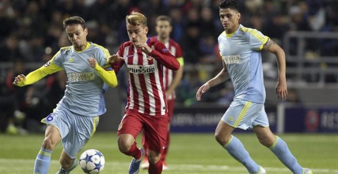 El delantero francés del Atlético de Madrid, Antoine Griezmann (c) lucha por el balón con Nemanja Maksimovic (i) del Astana. /EFE