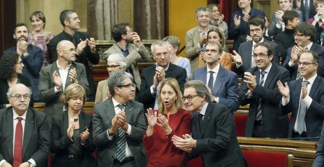 El presidente de la Generalitat en funciones, junto a miembros de su gobierno y diputados de Junts pel Si, aplaude tras aprobarse en el Parlament de Catalunya la resolución conjunta de Junts pel Sí y la CUP./ EFE
