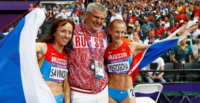 Fotografía de archivo fechada de las atletas rusas Mariya Savinova y Ekaterina Poistogova, junto a su entrenador.- EFE