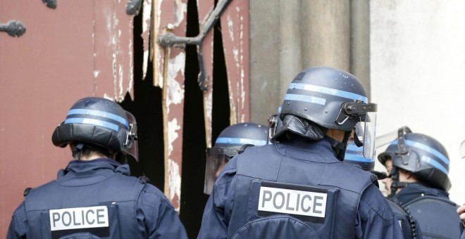 La policía francesa entran en la Iglesia un la iglesia de Saint-Denis después de romper la puerta con un hacha, durante la operación policial para capturar al presunto cerebro de los atentados de París.-  REUTERS / Jacky Naegelen