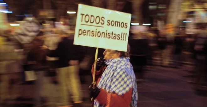 Una anciana con una pancarta que dice 'Todos somos pensionistas', en una manifestación contra las medidas del Gobierno. AFP / Pedro Armeste