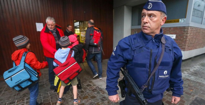 Un policía custodia la puerta de un colegio e Bruselas. REUTERS/Yves Herman