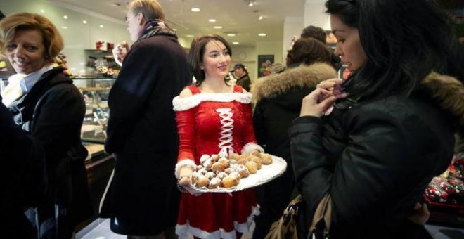 Una joven sirve postres navideños en una pastelería.- EFE