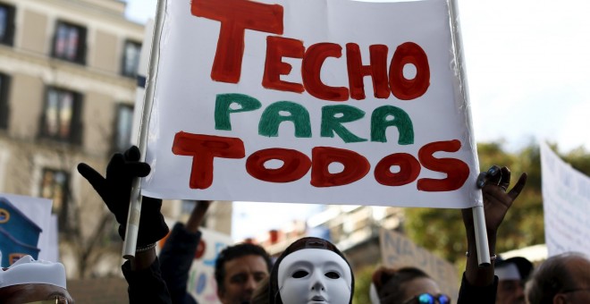 Un manifestante sujeta una pancarta donde se lee 'TECHO PARA TODOS' en la protesta convocada por la plataforma 'Nadie sin Hogar' por el derecho a la vivienda, en el centro de Madrid, España, 26 de noviembre de economía 2015. REUTERS / Paul Hanna