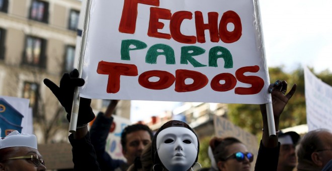 Un manifestante sujeta una pancarta donde se lee 'TECHO PARA TODOS' en la protesta convocada por la plataforma 'Nadie sin Hogar' por el derecho a la vivienda, en el centro de Madrid, España, 26 de noviembre de economía 2015. REUTERS / Paul Hanna