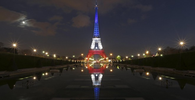 La Torre Eiffel encendida con los colores de la bandera francesa tras los atentados de París. REUTERS/Christian Hartmann