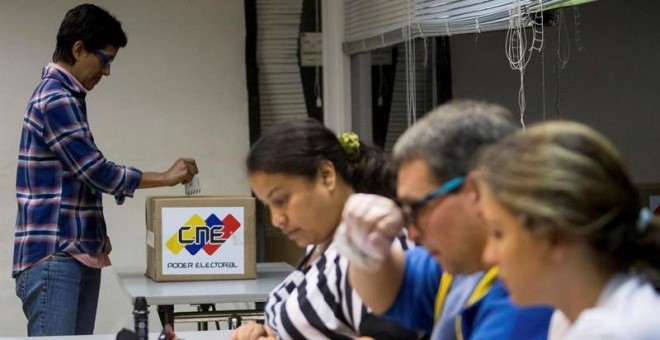 Una mujer vota en un colegio electoral de la ciudad de Caracas. Los colegios electorales de Venezuela abrieron hoy para que casi 19,5 millones de ciudadanos convocados puedan votar para renovar la unicameral Asamblea Nacional (AN, Parlamento) de 167 escañ