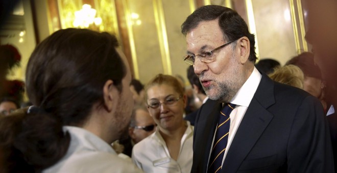 El presidente del Gobierno y candidato a la reelección, Mariano Rajoy, conversa el candidato de Podemos, Pablo Iglesias, en la recepción celebrada en el Congreso de los Diputados con motivo del XXXVII aniversario de la Constitución. REUTERS/Susana Vera