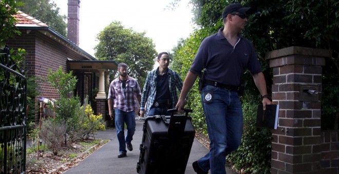 Agentes de la policía australiana salen del domicilio de Wright tras el registro. REUTERS/David Gray