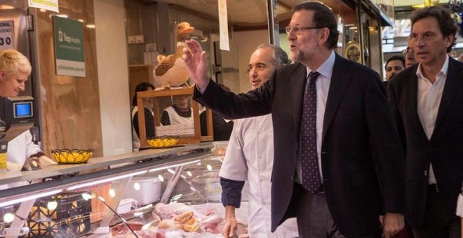 El candidato a la reelección como presidente del Gobierno, Mariano Rajoy (c), junto al número uno de la lista del PP balear al Congreso, Mateo Isern (d), ha visitado el mercado del Olivar, antes de intervenir en el mitin del PP en el Parc de la Mar en Pa