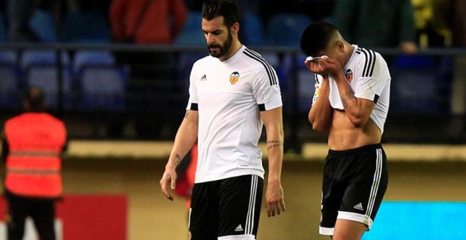 El delantero del Valencia Álvaro Negredo (i) abandona desolado el terreno de juego tras perder contra el Villarreal. EFE