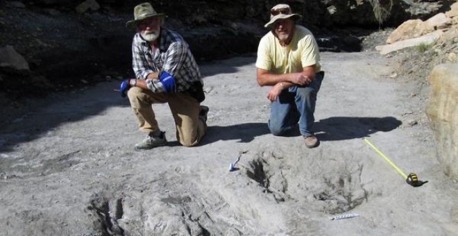 Los investigadores Martin Lockley (derecha) y Ken Cesta posan junto a los grandes rasguños de dinosaurio que descubrieron en el oeste de Colorado / Universidad de Colorado