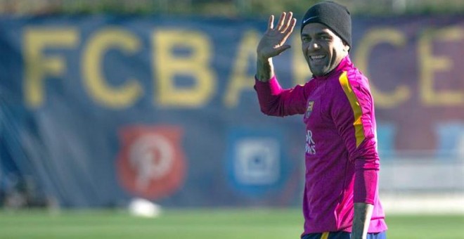 El defensa brasileño del FC Barcelona, Dani Alves, saluda a los medios al inicio del entrenamiento de este viernes. /EFE