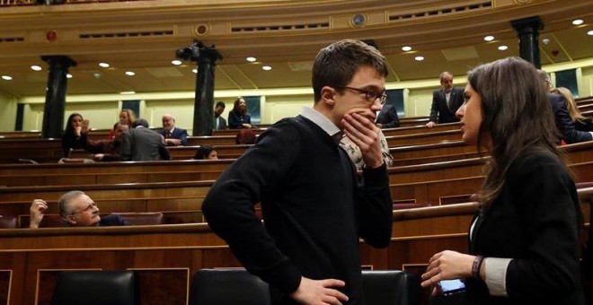 Los diputados de Podemos Iñigo Errejón e Irene Montero conversan en el hemiciclo del Congreso.- EFE