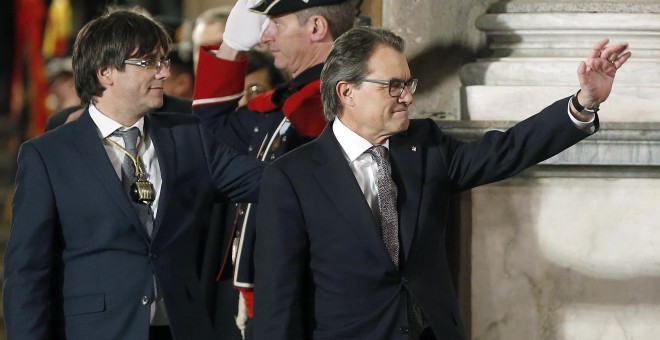 El expresidente de la Generalitat, Artur Mas, abandona el Palau de la Generalitat acompañado del nuevo presidente, Carles Puigdemont tras el acto de toma de posesión. EFE/Andreu Dalmau