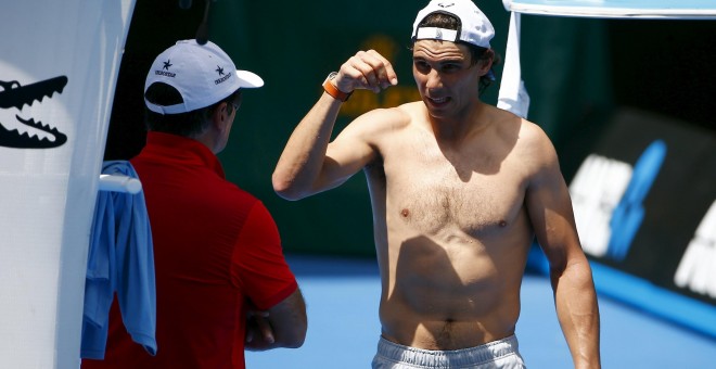 Nadal habla con su tío y entrenador, Toni Nadal, durante un entrenamiento en Melbourne Park. /REUTERS