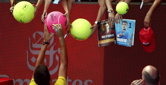Un jugador firma autógrafos a aficionados en el Open de Australia./REUTERS
