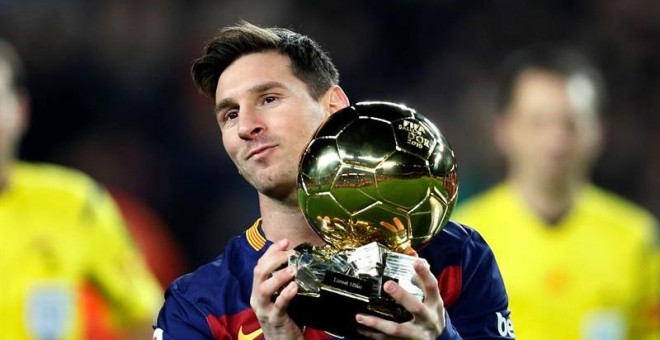 El delantero del Barcelona Lionel Messi ofrece su quinto Balón de Oro a la afición. /EFE