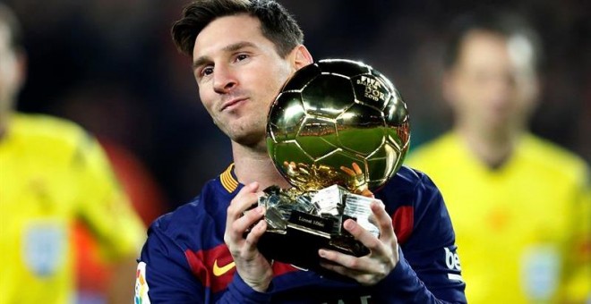 El delantero del Barcelona Lionel Messi ofrece su quinto Balón de Oro a la afición. /EFE