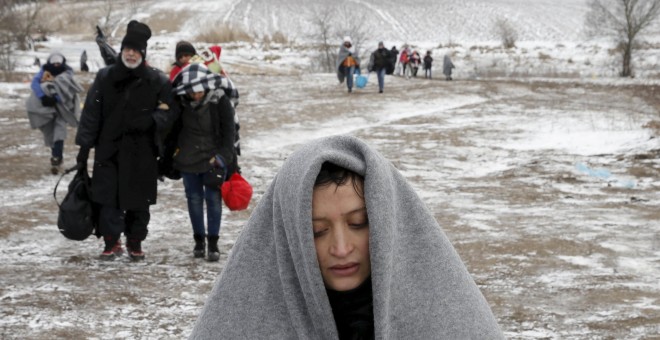 Refugiados sirios que huyen de la guerra en su país llegan por terrenos helados a la frontera de Macedonia. - REUTERS