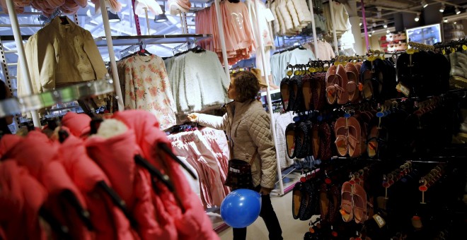 Foto de archivo de una mujer mirando ropa en una tienda de Madrid. REUTERS